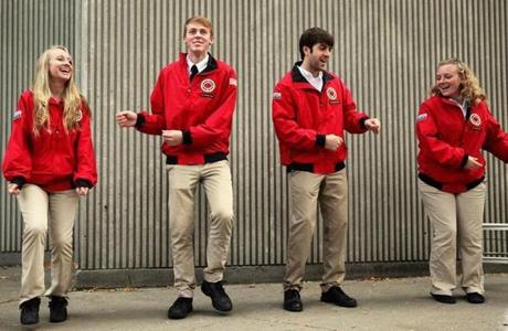 From the left, City Year members Robin Tucker, Zak Kephart, Alex Hallenbeck, and Danielle West prepared to greet students outside the Condon School in South Boston. 
